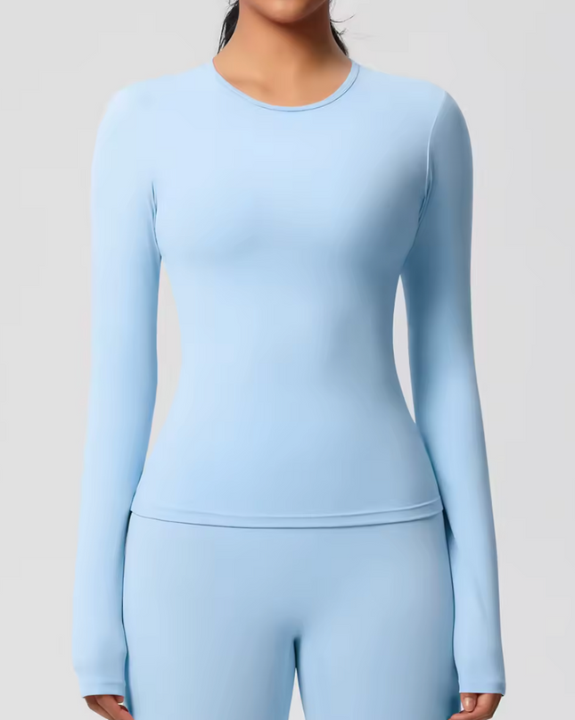 Light blue long-sleeve underscrub top worn by a person on a plain background