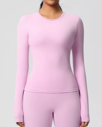 Person wearing a pink long-sleeve underscrub top and pants on a light gray background